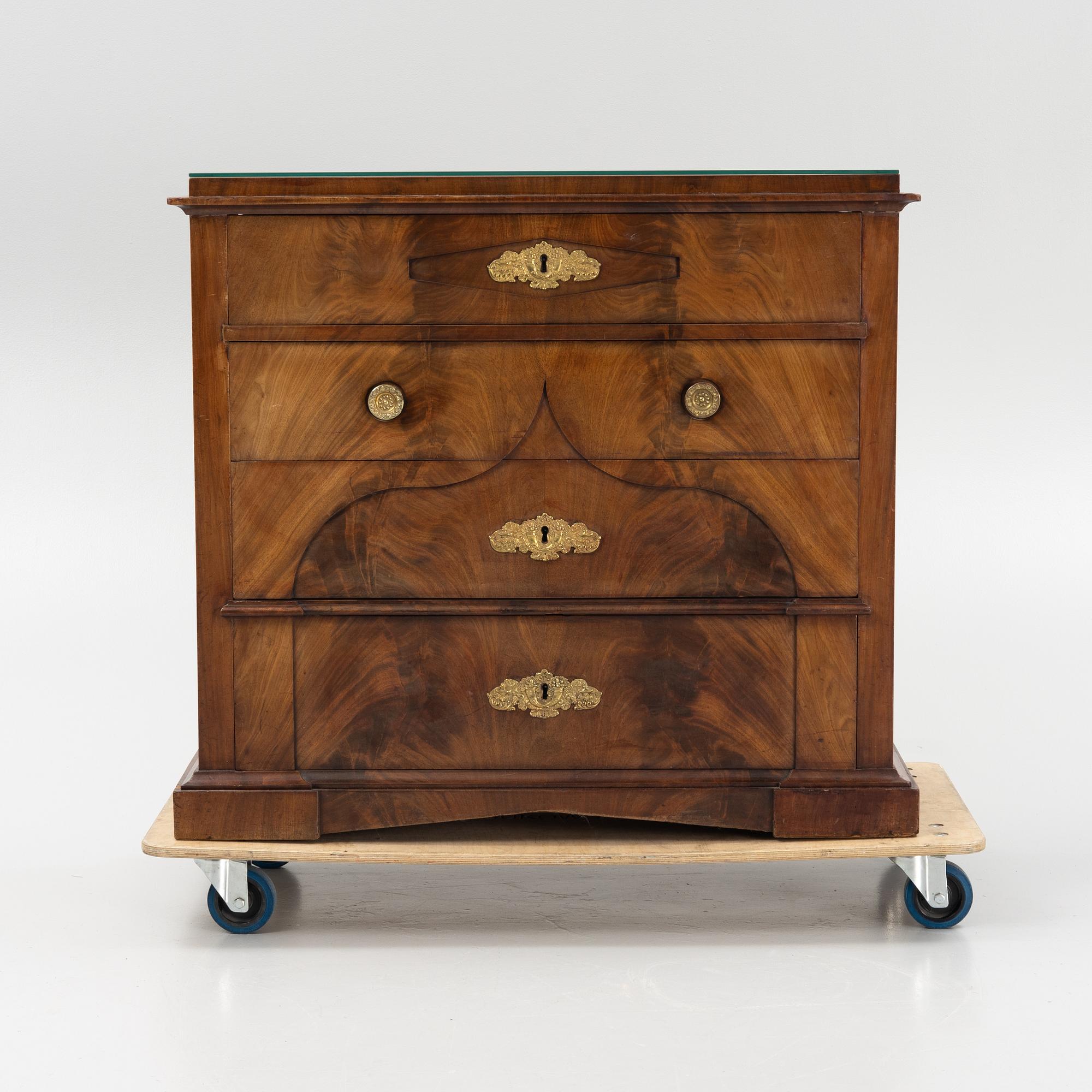 A mahogany veneered Empire chest of drawers, first half of the 20th Century.