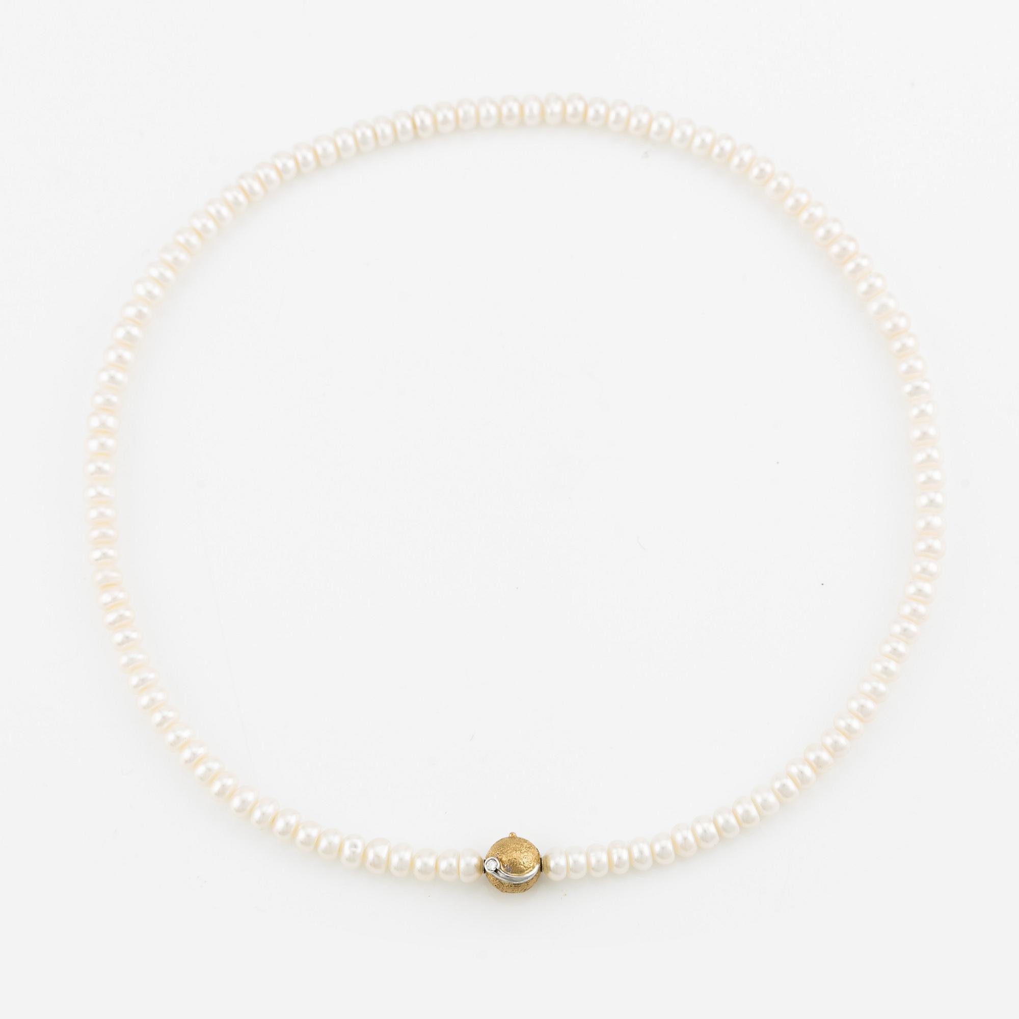 Ole Lynggaard clasp in 18K gold with a round brilliant-cut diamond and a freshwater cultured pearl necklace.