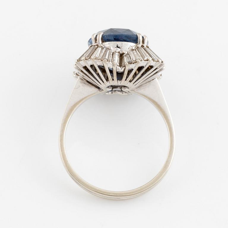 An 18K gold ring set with a faceted sapphire and tapered baguette-cut diamonds.