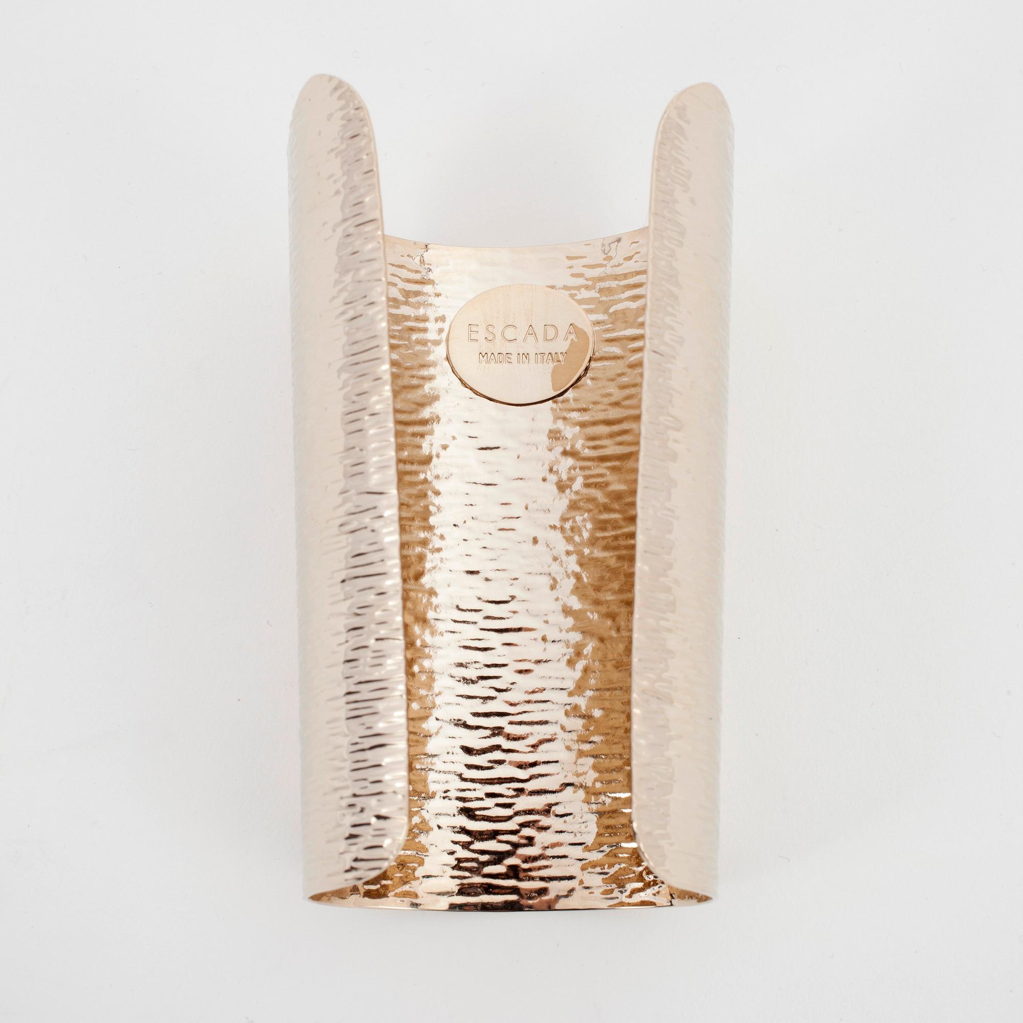 ESCADA, a golden metal bracelet.