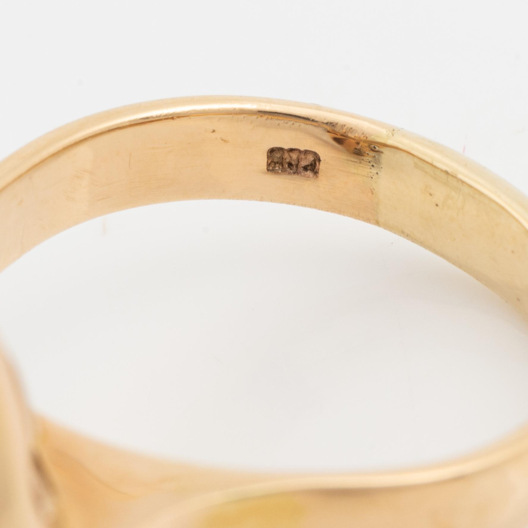 A 14 k gold ring set with a half pearl and round brilliant-cut diamonds.
