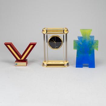 A collection of three sculptures and a mantel clock.