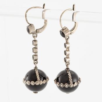 Örhängen silver med svarta stenar.
