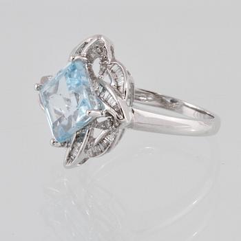 RING, 18K vitguld med carréslipad blå topas 4.07 ct samt baguett och briljantslipade diamanter 0.36 ct. Vikt 4,1 gram.