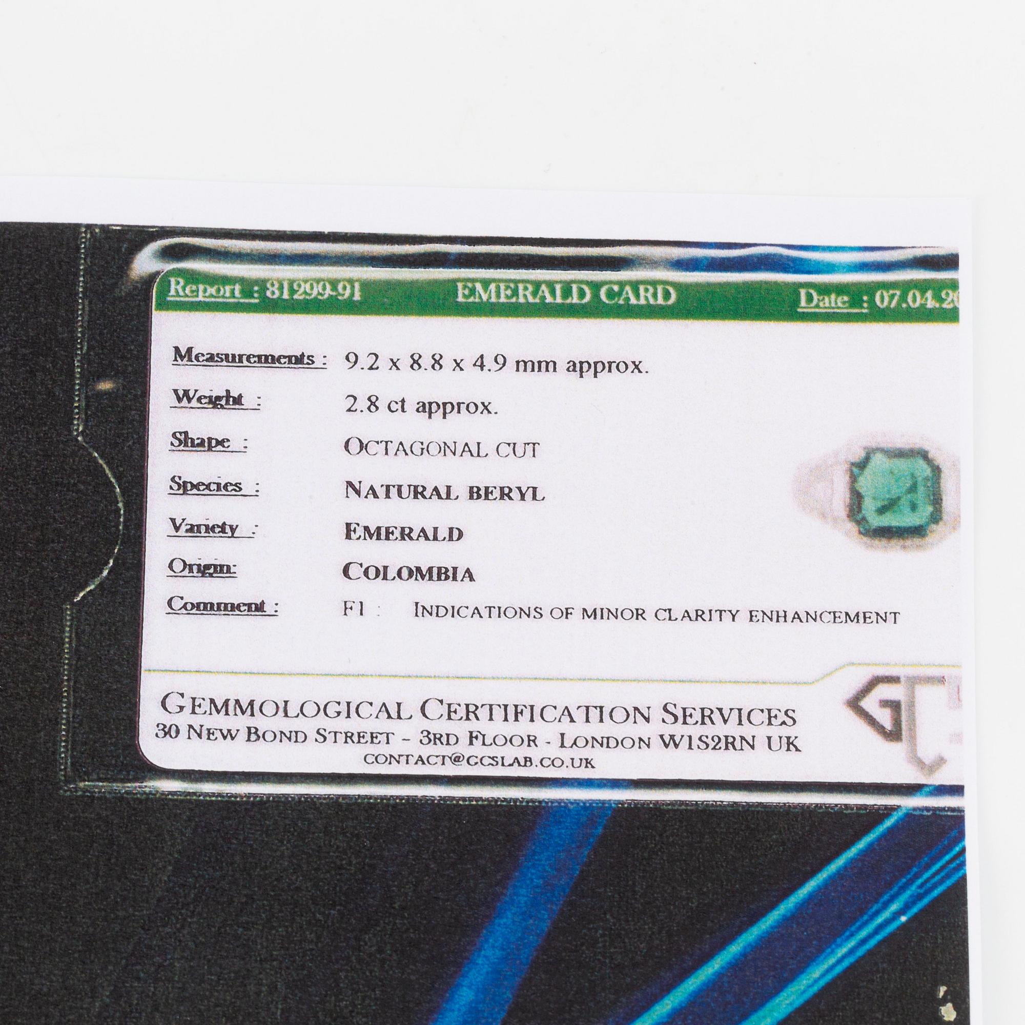 A Bulgari "Trombino" ring in platinum set with a step-cut emerald and round brilliant- and baguette-cut diamonds.