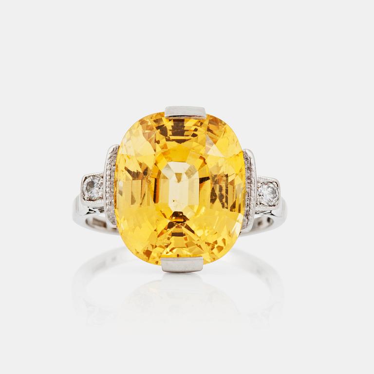 A circa 13.50 ct fancy yellow sapphire and brilliant-cut diamond ring. Total carat weight of diamonds circa 0.10 ct.