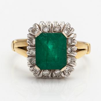An 18K gold ring with diamonds ca. 0.21 ct and an emerald.