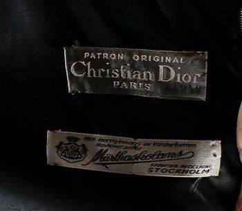 A black three-piece 1960s/70s ensemble consisting of trousers, top and scarf by Christian Dior.