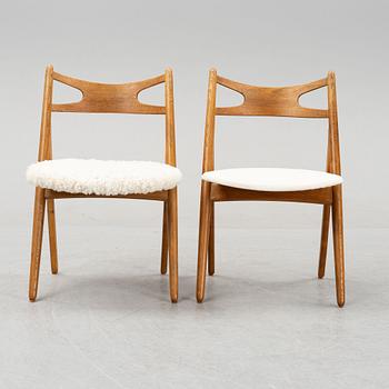 A set of six model CH 29 oak chairs by Hans J Wegner, two with leather upholstery and four with sheepskin.