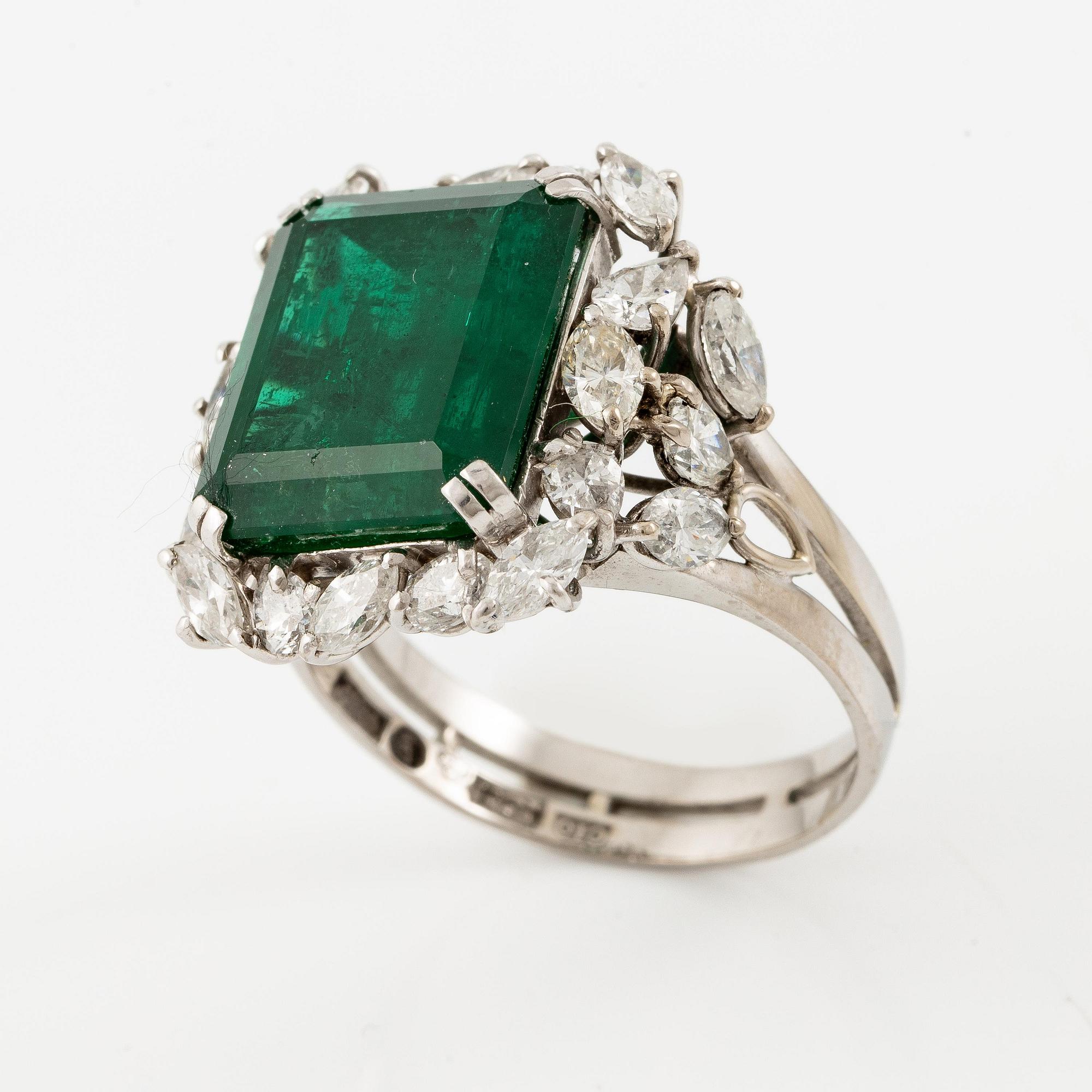 An 18K white gold ring set with a step-cut emerald.