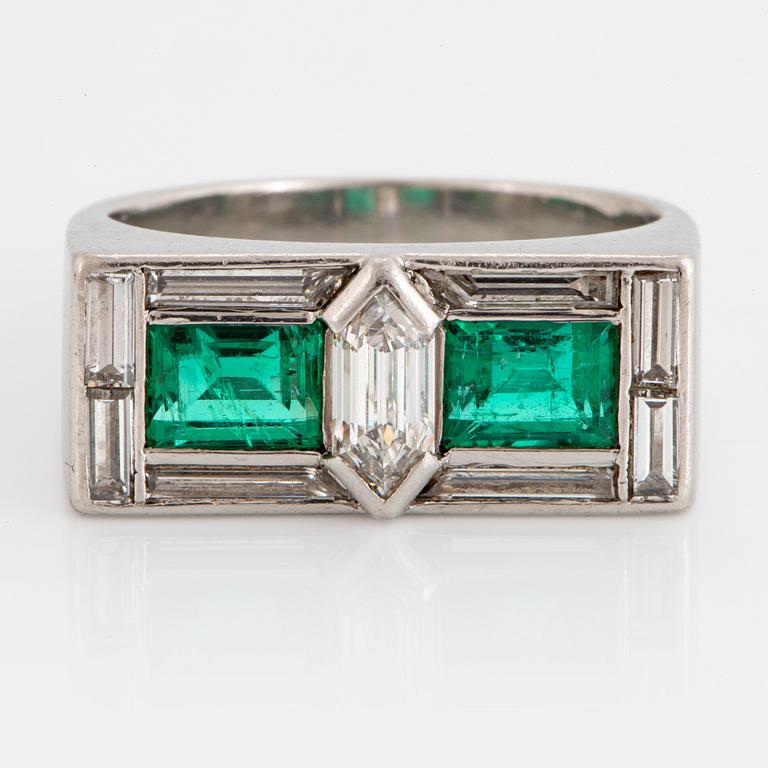 A platinum ring set with faceted emeralds and diamonds.