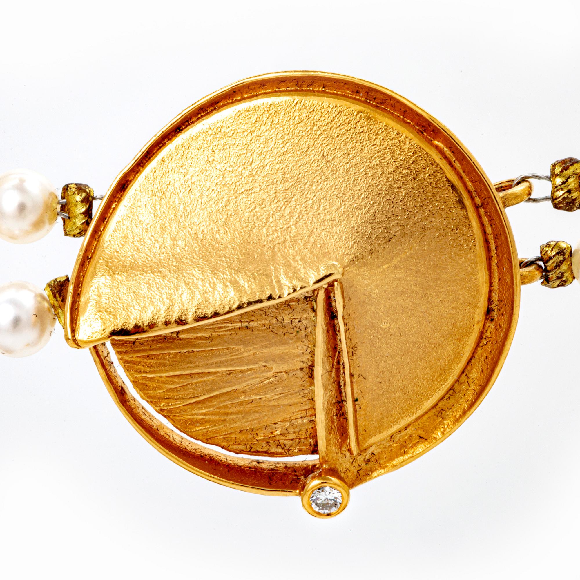A necklace of cultured pearls and pendant in 18K gold with a brilliant cut diamond.