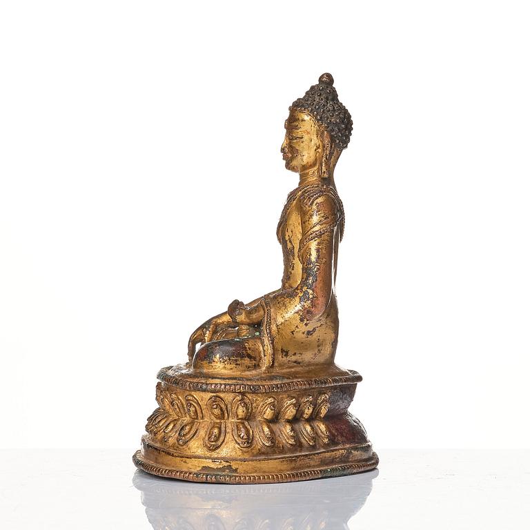 A gilt copper alloy figure of Buddha, Tibet/Nepal 15th Century.