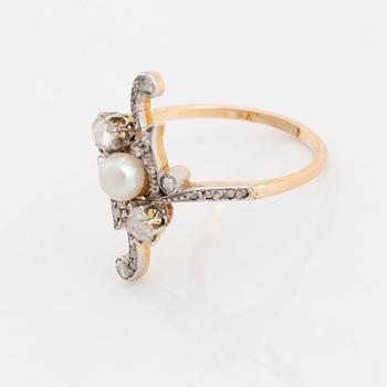 A platinum and gold ring set with a pearl and rose-cut diamonds.