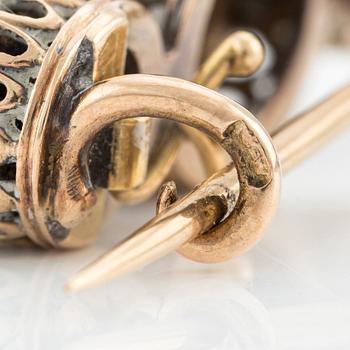 A brooch in silver and gold with a pearl and two rose-cut diamonds.