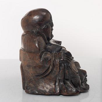A Chinese wooden figure of Budai with silver inlays, Qing dynasty (1644-1912).
