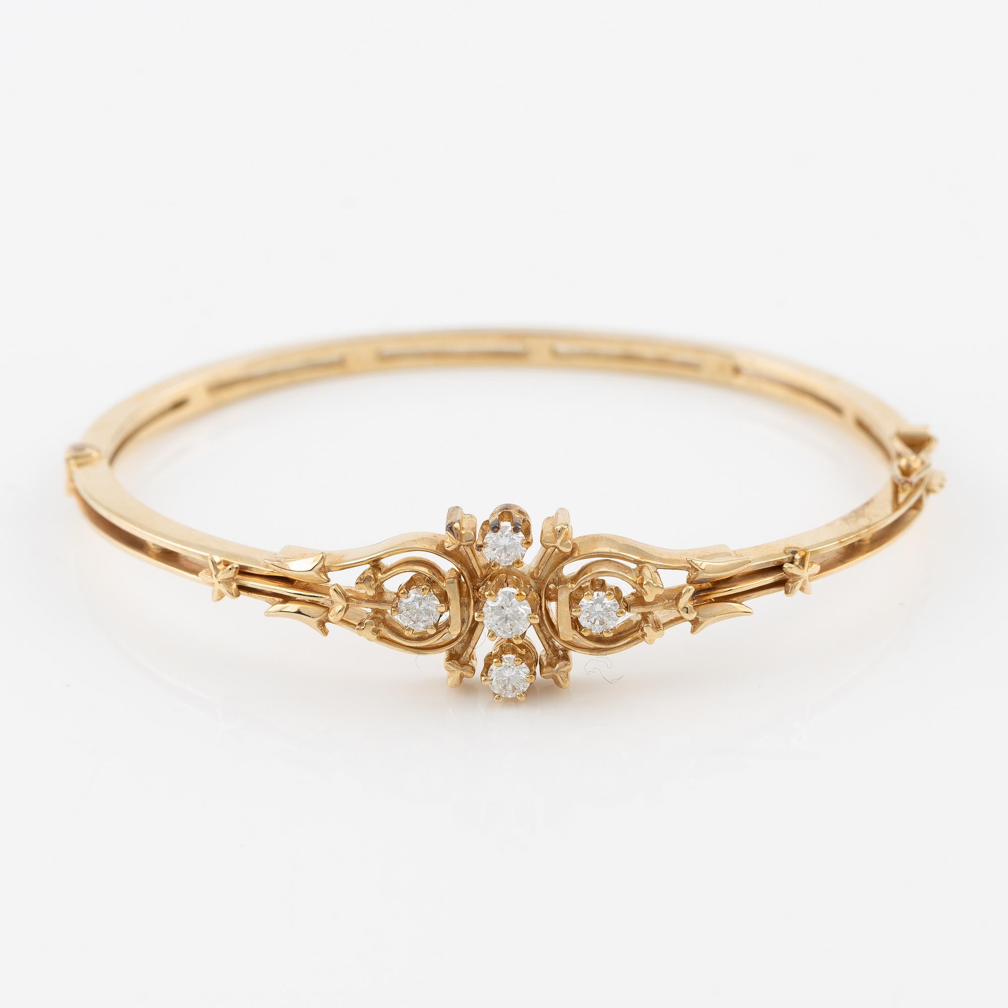 A bangle in 14K gold with round brilliant-cut diamonds.