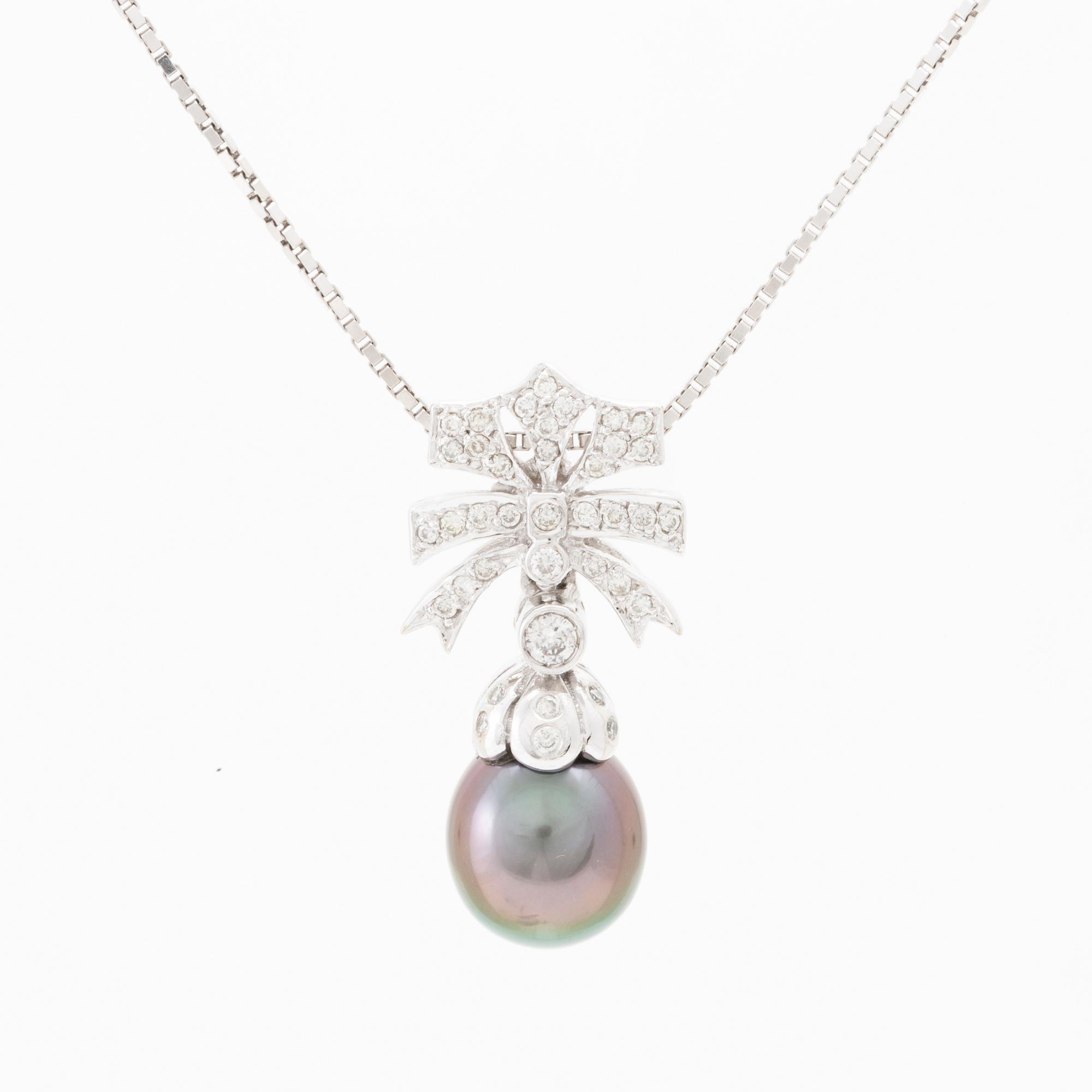 An 18K white gold necklace set with a drop-shaped cultured pearl and round brilliant-cut diamonds.