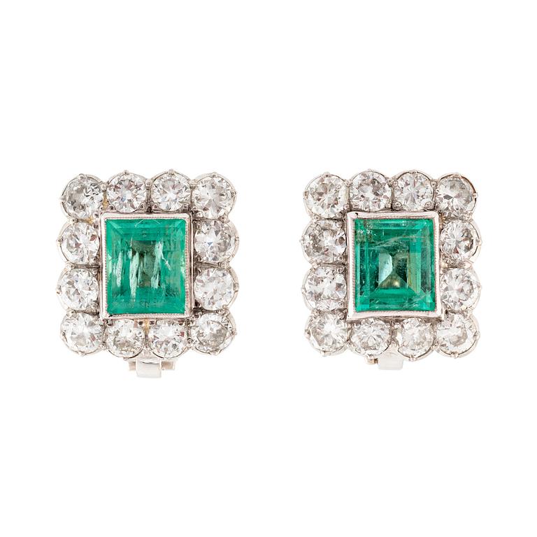 A pair of 14K gold earrings set with step-cut emeralds.