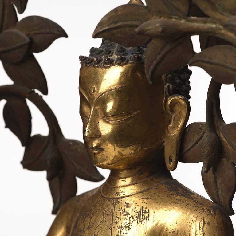 A large Nepalese gilt bronze buddha on a throne with mandorla, 18/19th Century.
