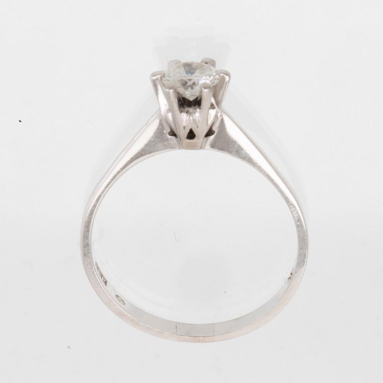 An 18K white gold solitaire ring set with a round brilliant-cut diamond.