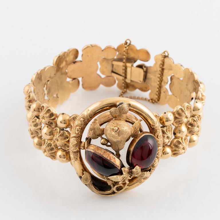 An 18K gold bracelet set with cabochon-cut garnets.