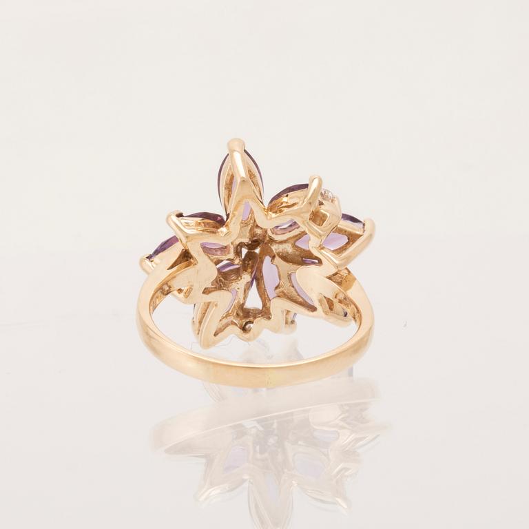 A 14K gold cocktail ring set with round brilliant-cut diamonds and navette-cut amethysts.