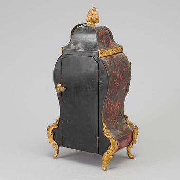 A Louis XV-style mantle clock with console base.