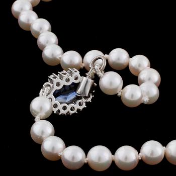 A cultured pearl necklace with a sapphire and diamond clasp.