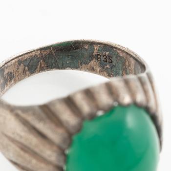 Silver ring with a green cabochon-cut stone.