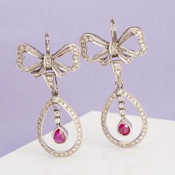 A pair of ruby and single-cut diamond earrings in the shape of bows. .