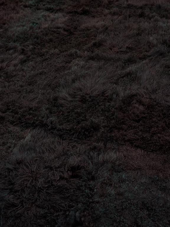 A carpet, sheepskins, black dark brown green melange, ca 547 x 492-498 cm.
