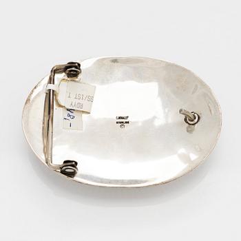 Chester Benally, a silver belt buckle with a turquoise, Navajo.