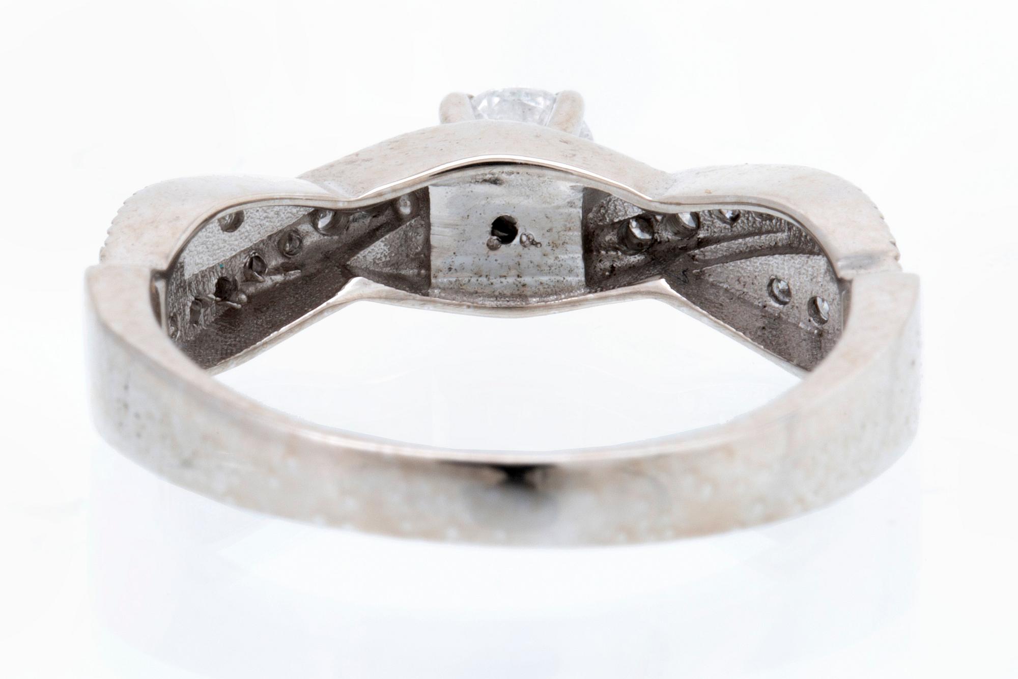 Ring 18K vitguld med 1 briljant ca 0,30 ct och briljanter ca 0,15 ct totalt.