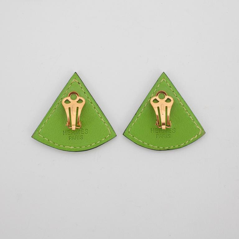 HERMÈS, a pair of green leather clip earings from the 1990s.