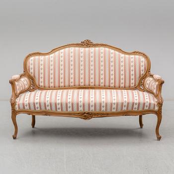 An end of the 19th Century rococo style walnut sofa with four chairs, two armchairs and a table.