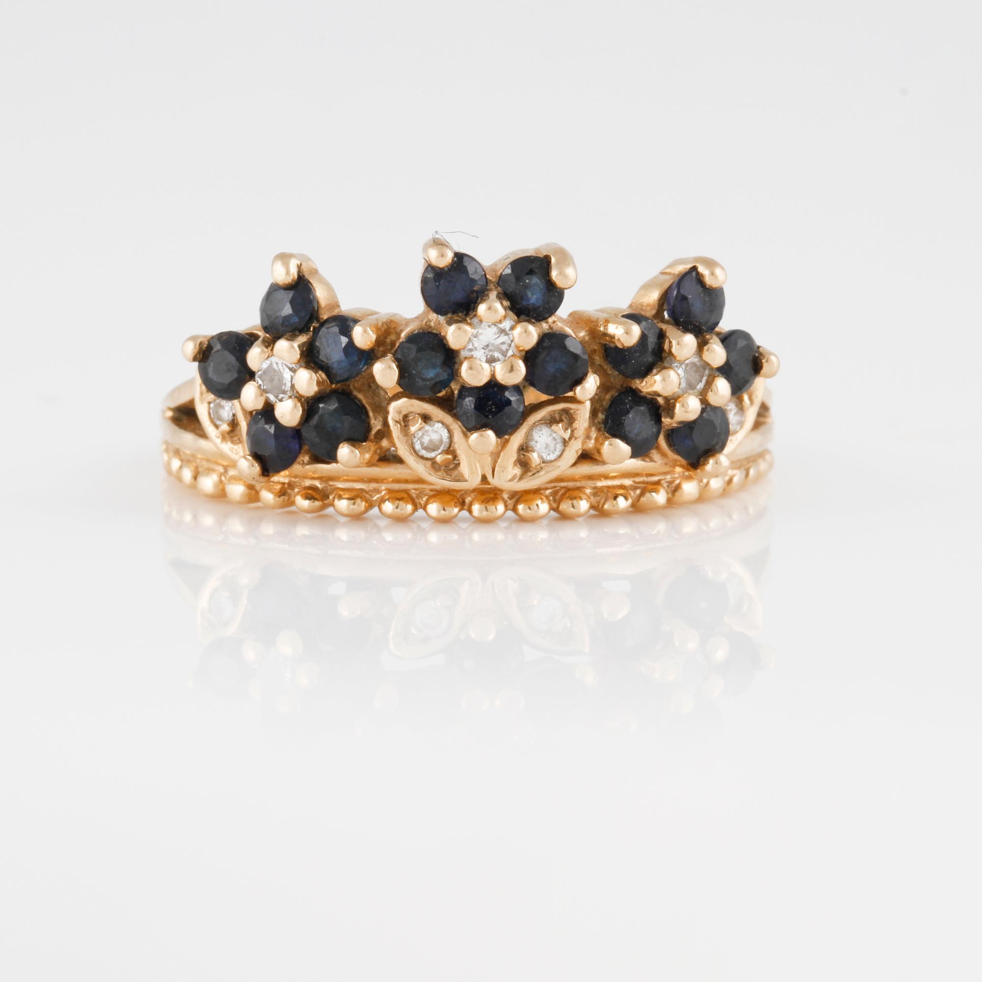 RING, 14K guld med sju briljantslipade diamanter samt femton blå safirer. Vikt 4,5 gram.