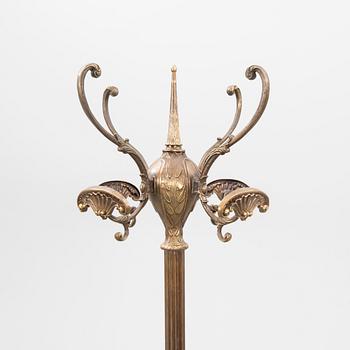 A brass coat hanger from the first half of the 20th century.