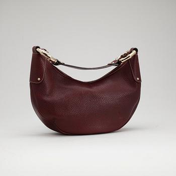 GUCCI, a dark burgundy red shoulder bag.