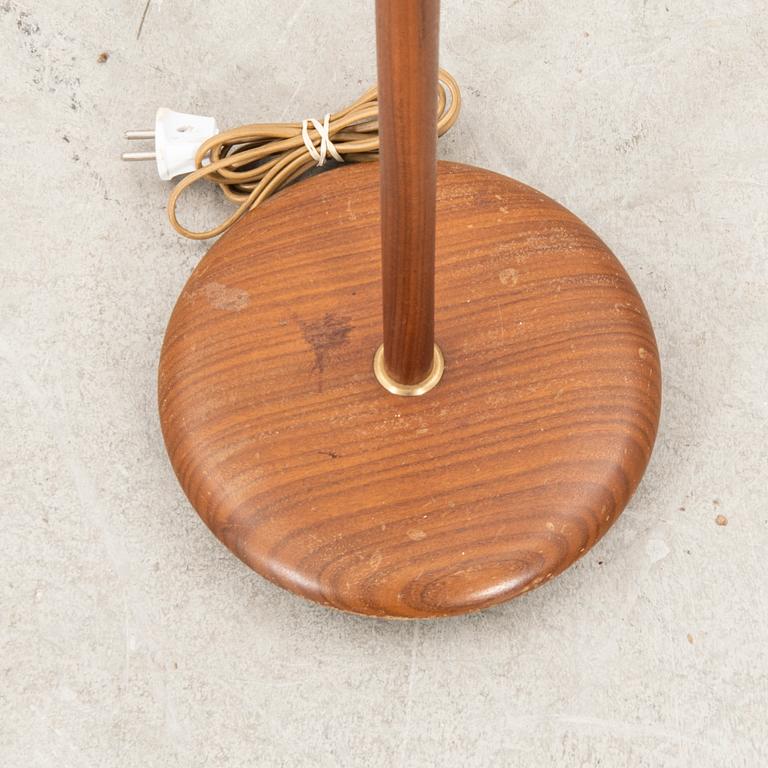A teak and brass floor lamp from the first half of the 20th century.