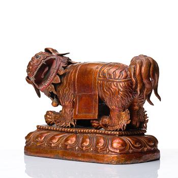 A cold gilt and lacquered copper alloy sculpture of a buddhist lion, Tibeto-Chinese/Mongolian, 18th Century.