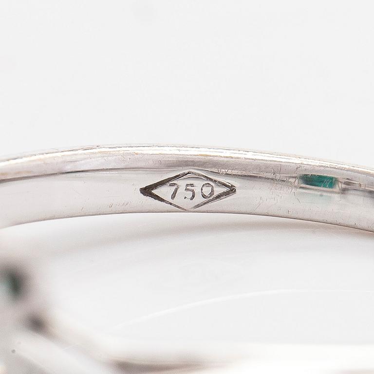 An 18K white gold ring, set with a Zambian emerald and trillion-cut diamonds.