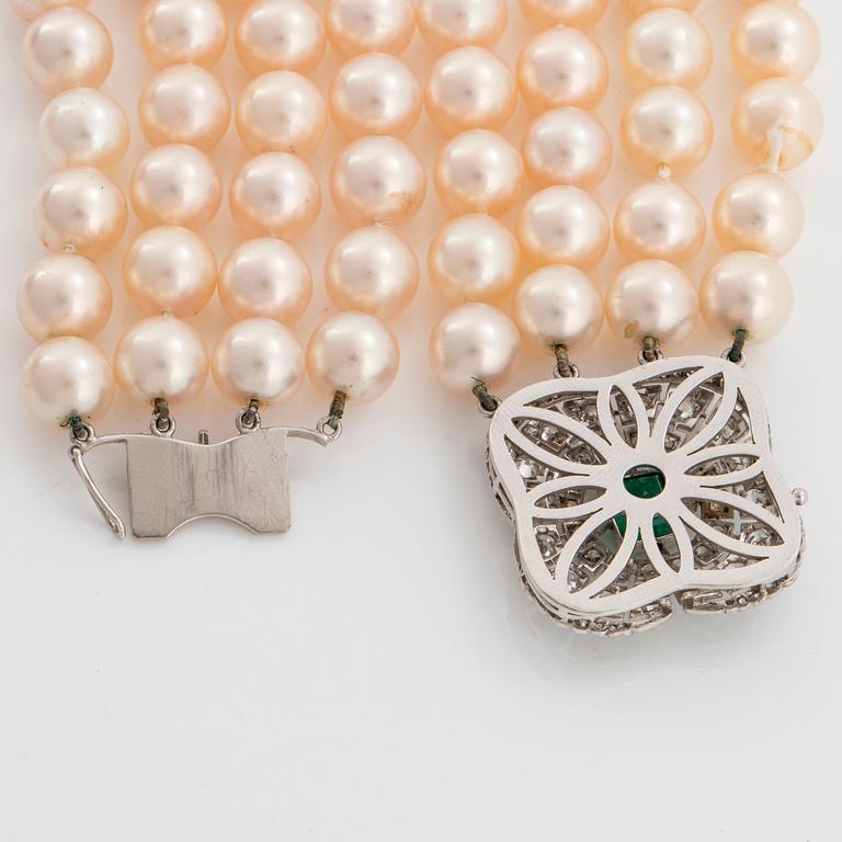 A four strand cultured pearl necklace with an 18K white gold clasp set with a faceted emerald.