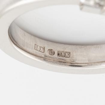 An 18K white gold ring set with a round brilliant-cut diamond.