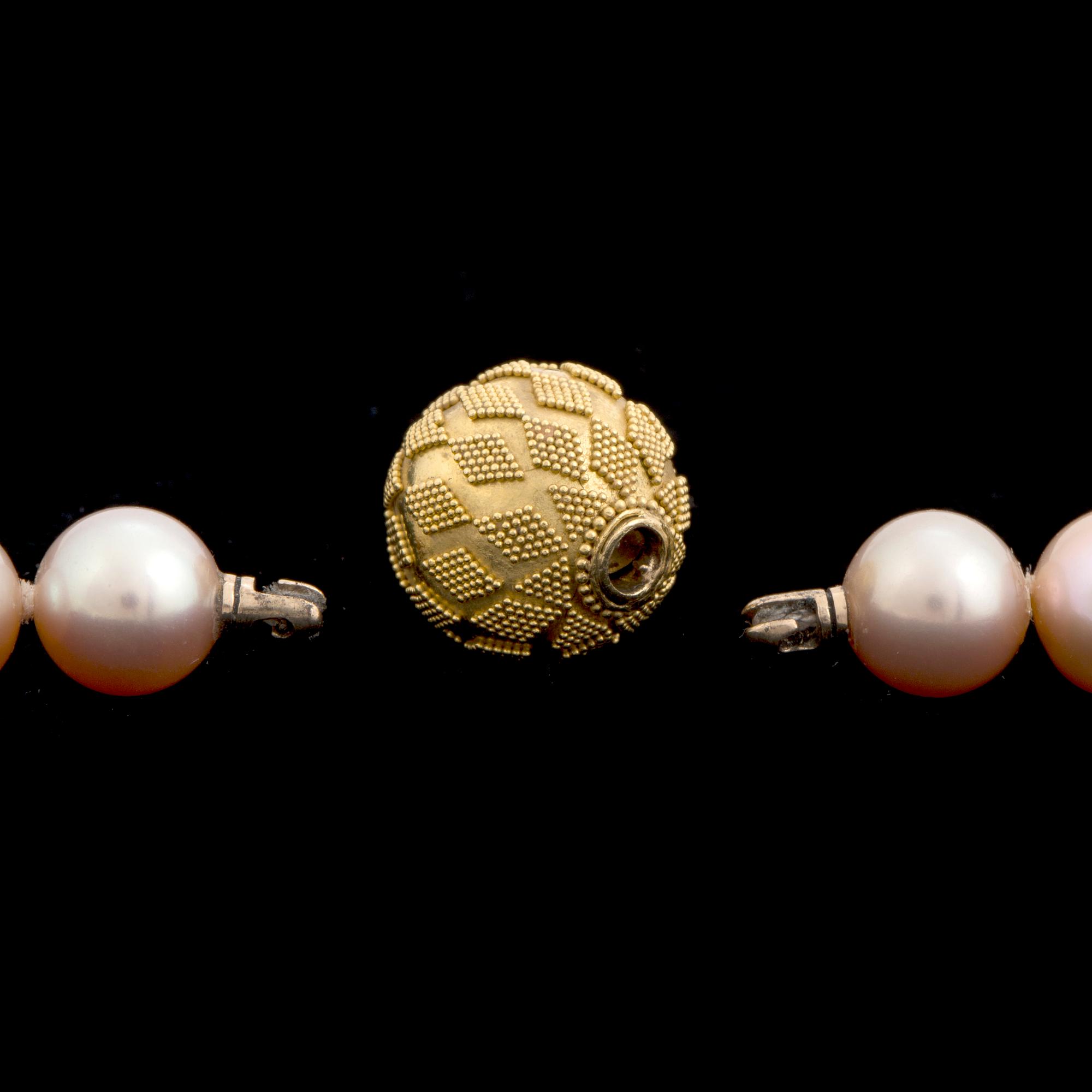 A pearl necklace with an 18K gold clasp by Gaudy according to information given.