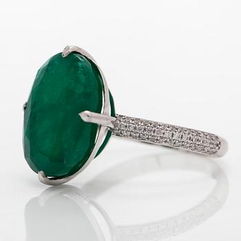 A 14K white gold ring, set with an oval-cut emerald and diamonds. Accompanied with IGI certificate.