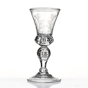 A cut and engraved glass goblet, dated 1755.