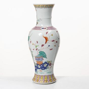 A slender famille rose 'flowers and antiques' vase, late Qing dynasty/early 20th century.