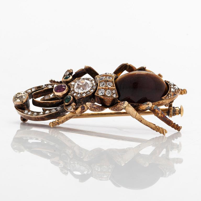 A 14K gold brooch with tiger’s eye, old-cut and rose-cut diamonds, ruby, emeralds. St. Petersburg.