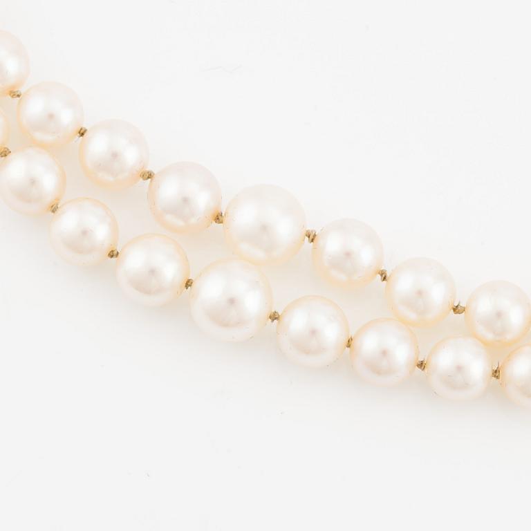 Pearl necklace, double-stranded with graduated cultured pearls, with an 18K gold clasp and cabochon-cut green tourmaline.